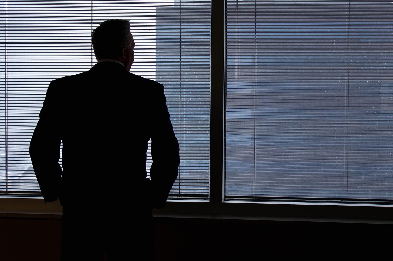 personne qui souffle et prend une courte pause devant une fenêtre, en pleine journée