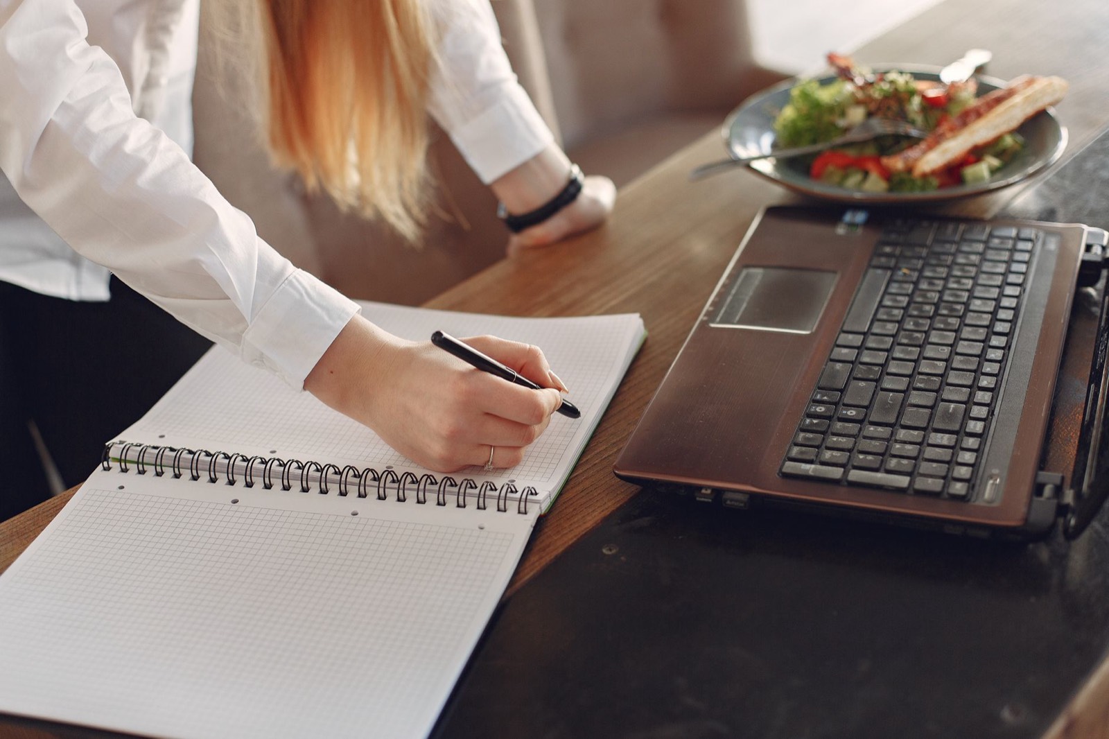 Salarié en pause fait un exercice de calcul mental sur un bloc-notes au bureau