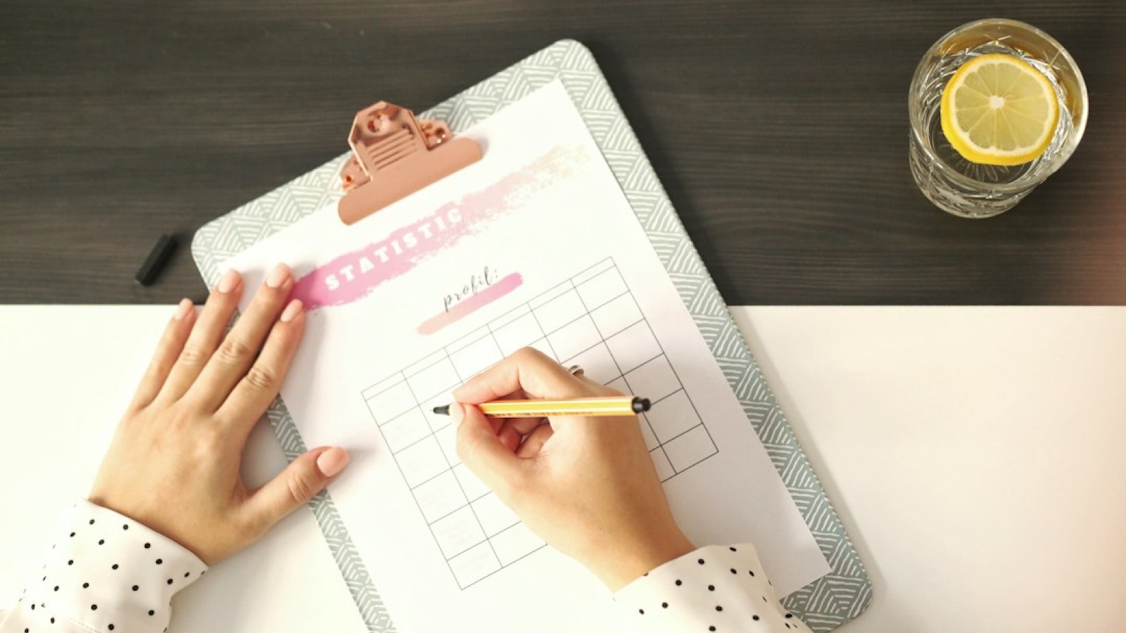 Calendrier mural et stylo posés sur une liste de tâches cochées