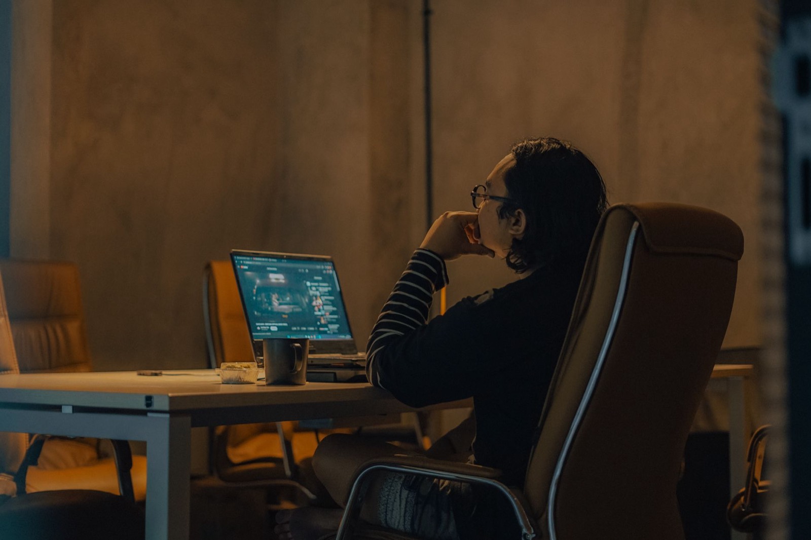 Salarié travaillant tard le soir sur son ordinateur portable, chez lui