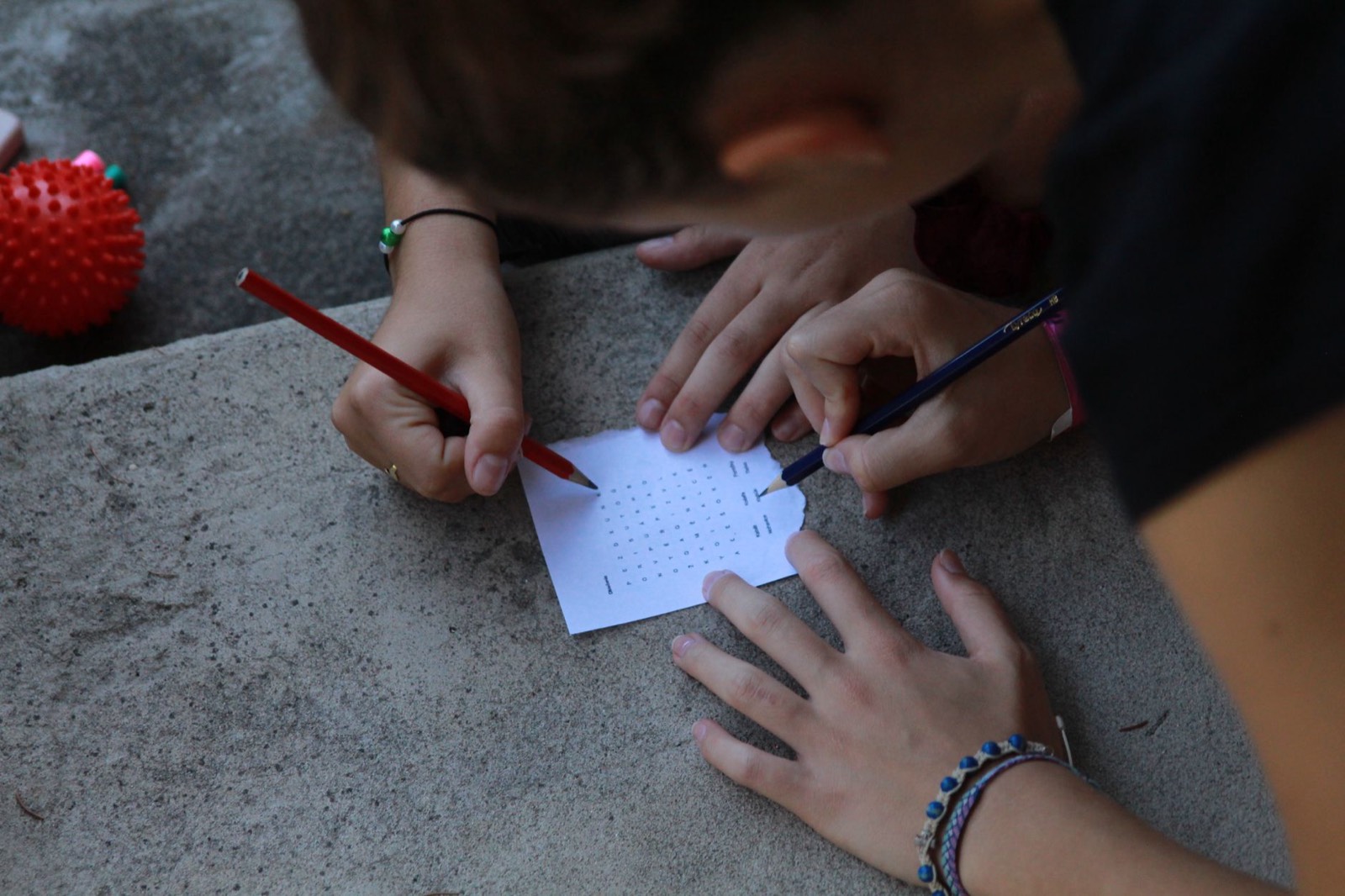 Gros plan sur une grille de sudoku remplie au crayon, main posée dessus