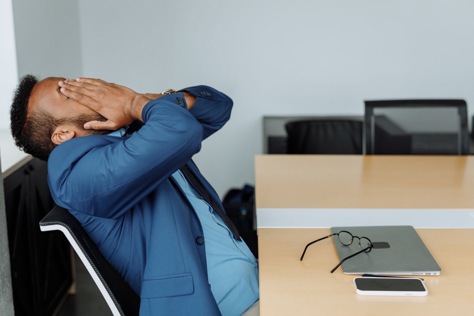 Salarié fatigué à son bureau après une journée de travail en tenue imposée